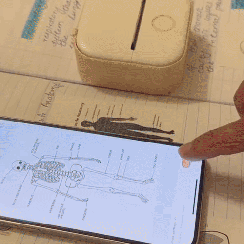 A smartphone prints a skeletal diagram onto a label using a small portable printer.